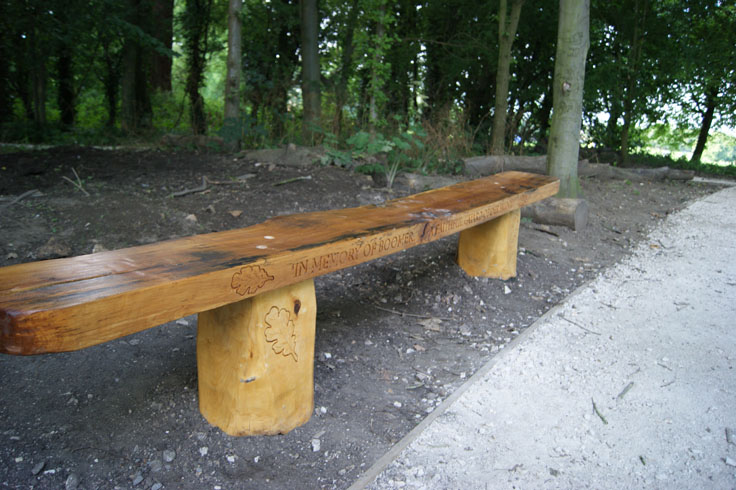 A memorial bench with ‘in memory of boomer’ inscribed on it.